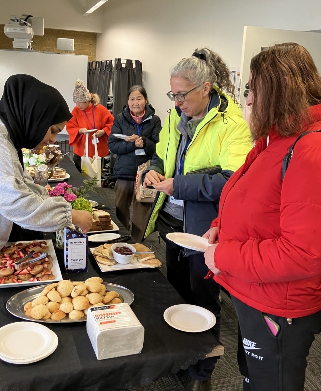 People collecting food from the morning tea table