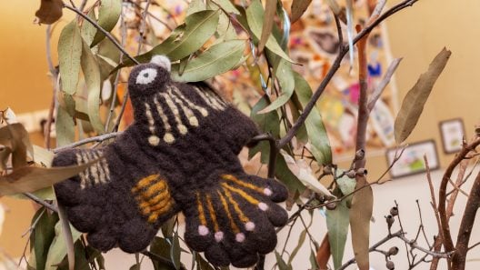 Bundjil the eagle made from felt, sitting in an indoor tree